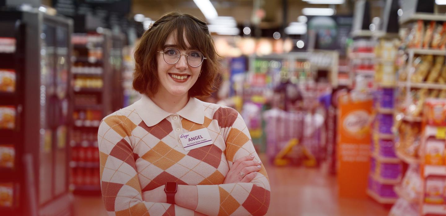 Kroger Assistant Store Leader Angel stands in her store and smiles at the camera