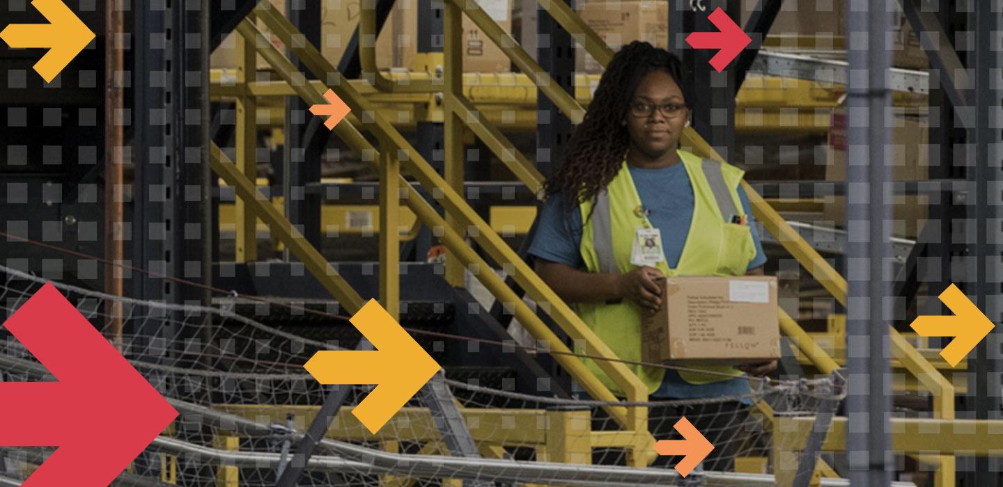 Retail factory worker in yellow vest moves a box