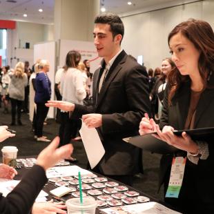 a guy and a girl set of students talking to a lady at the student program career fair 2018