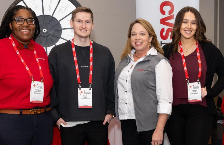 Four recruiters pose in front of the CVS Health booth during an NRF Foundation Career Fair.