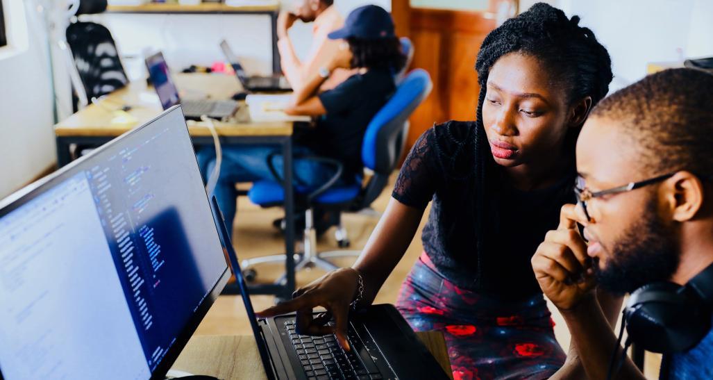 A girl and a guy are on a computer working