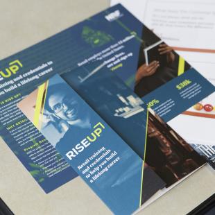 A RISE Up brochure on a table