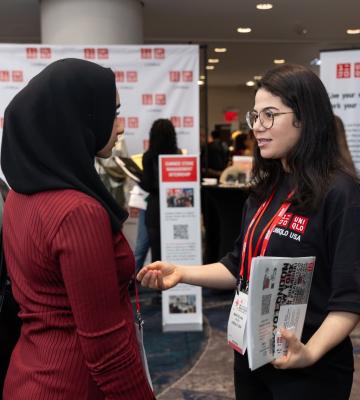 At the Student Program 2024 Career Fair, a UNIQLO recruiter speaks to an attendee