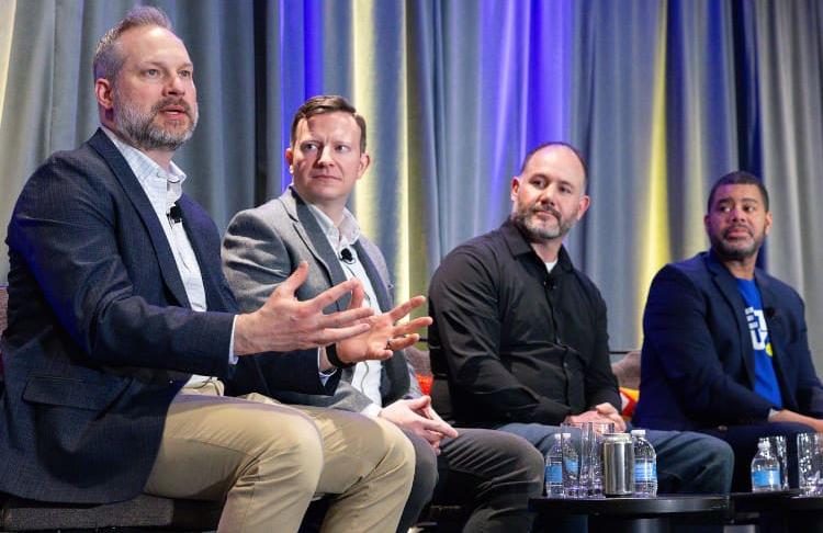 Four men sit on stage answering questions about the tech and supply chain aspects of the retail industry at the Student Program 2025 Tech & Supply Chain breakout session.